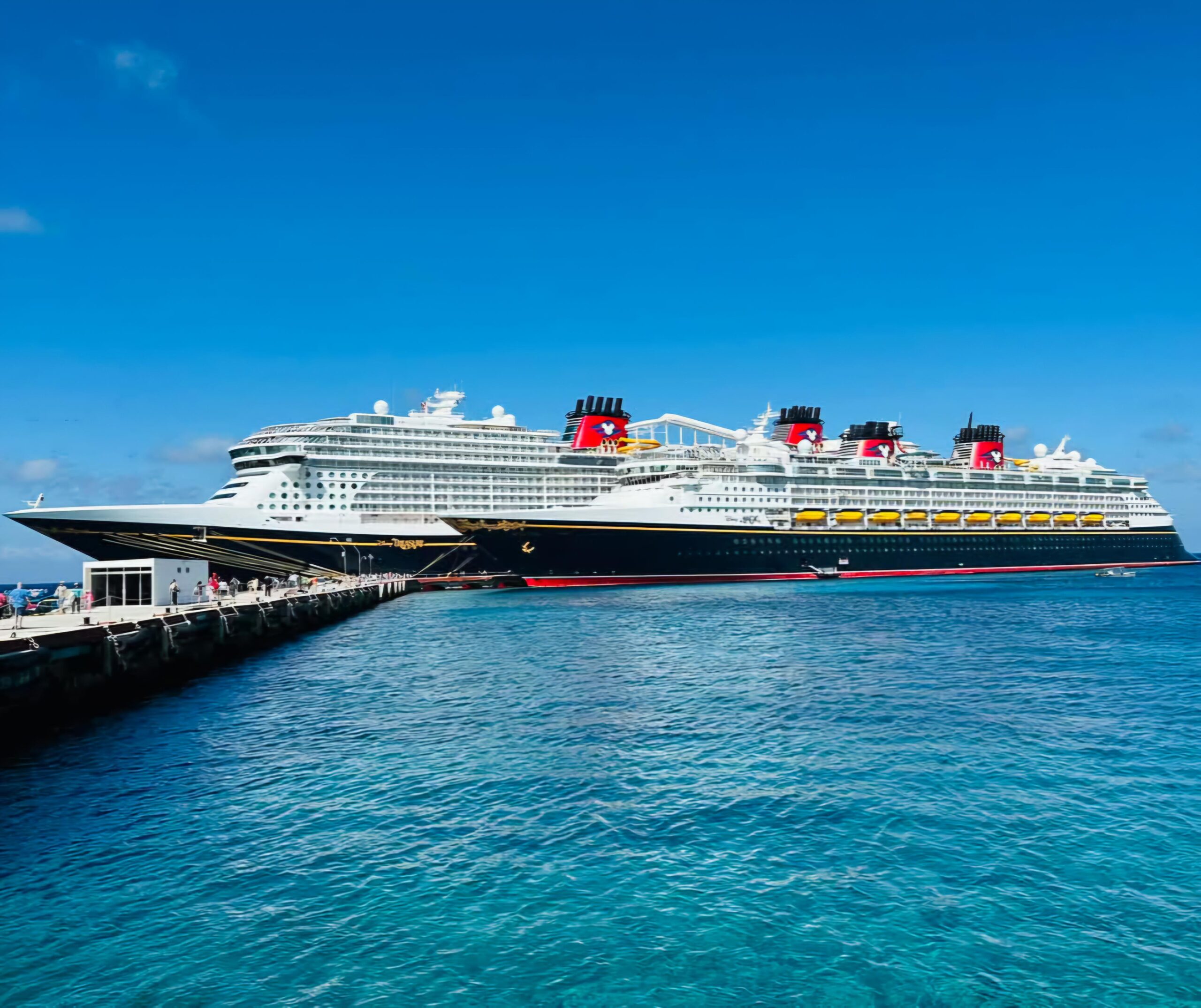 Barco Disney Dream en puerto en Cozumel, Mexico. Se ve el agua turquesa y cristalina.