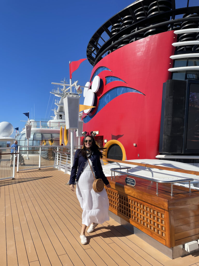 Mujer caminando sobre la cubierta de un barco de Disney Cruise Line