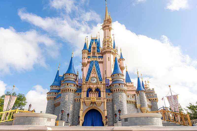 Castillo de la Cenicienta en Magic Kingdom en Walt Disney World visto de frente. Lo enmarca un cielo azulado y nubes.